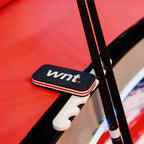 Black and white 'wnt.' logo cue stand on a red background
