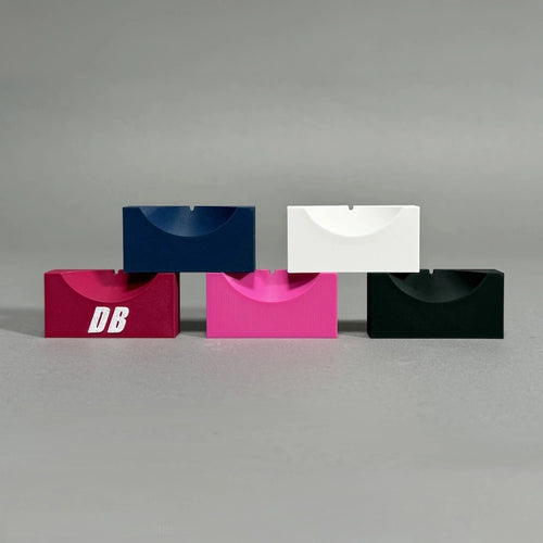 Five colorful ball markers stacked on a gray background